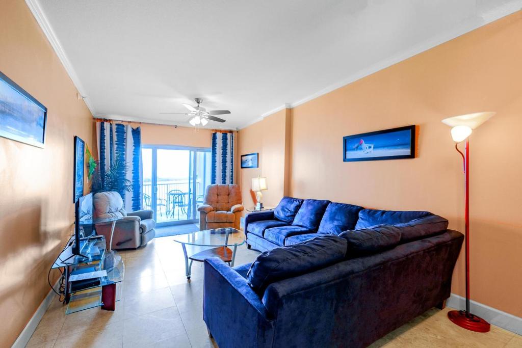 un salon avec un canapé bleu et une télévision dans l'établissement Sea Breeze 404 Deluxe, à Biloxi