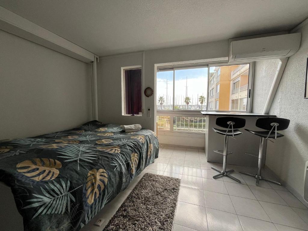 - une chambre avec un lit et une grande fenêtre dans l'établissement Appartement proche du port à Gruissan, à Gruissan