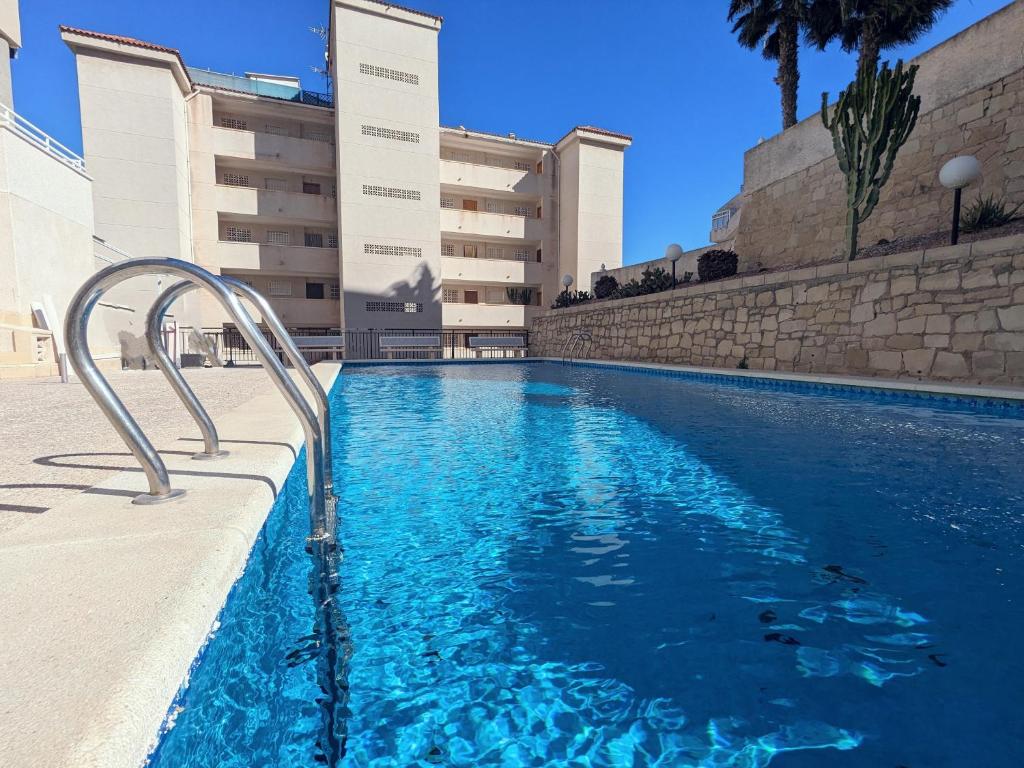 uma piscina em frente a um edifício em Apartamento sol y dunas em Arenales del Sol