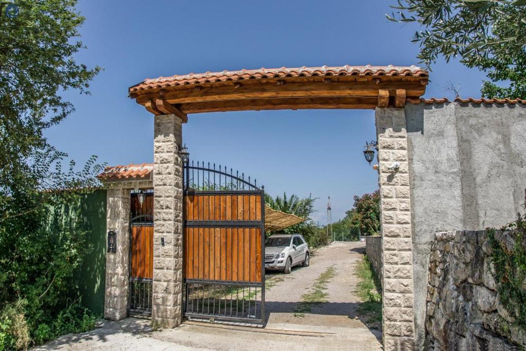 una puerta a una casa con un coche aparcado debajo en Villa Marco Polo with swimming pool, en Budva