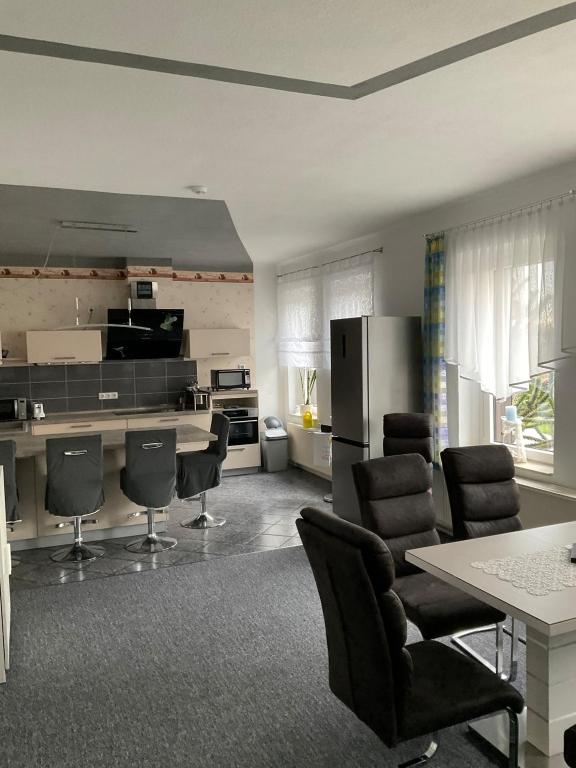 a kitchen with a table and chairs and a refrigerator at Apartment an der Honigbar in Leipzig