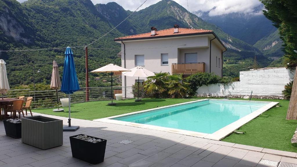 a villa with a swimming pool in front of a house at Villa sogno Garda lake in Tenno