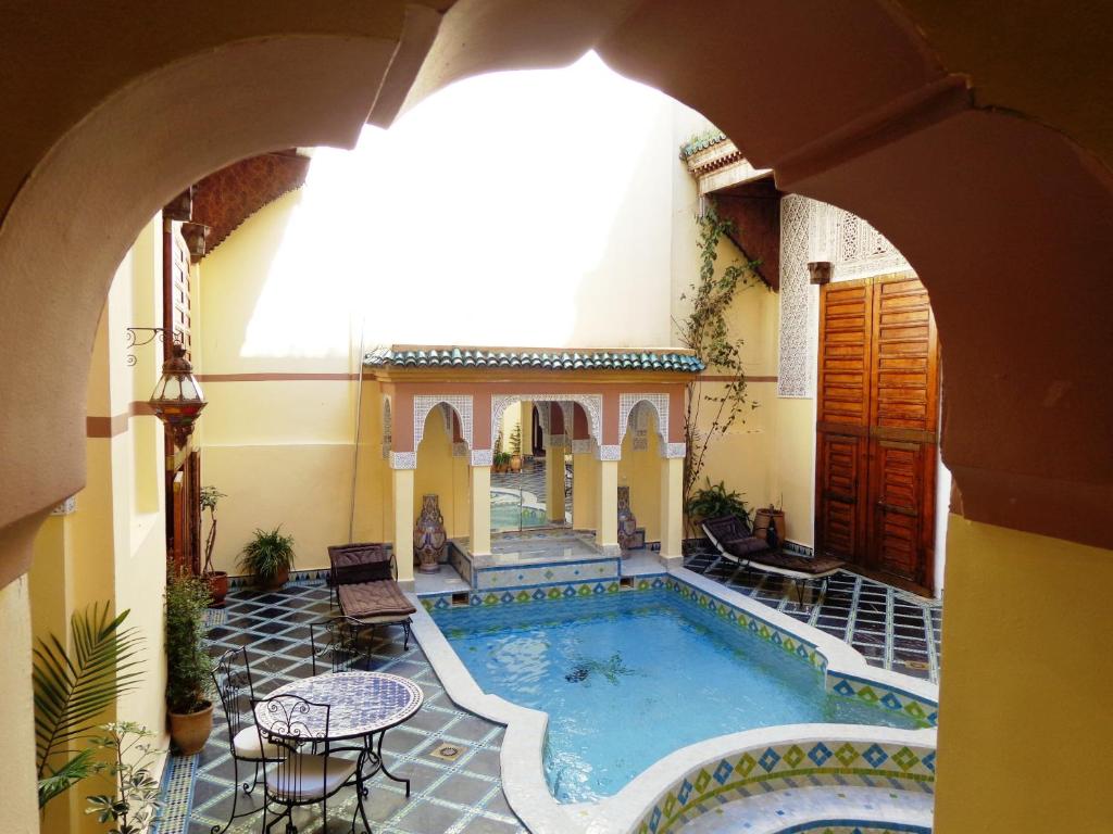 an indoor swimming pool in a building with an archway at Riad Zitouna in Fez