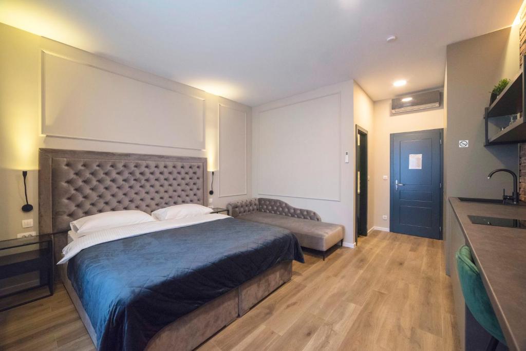 um quarto com uma cama grande e um cobertor azul em Imperial Apartment B em Zagreb