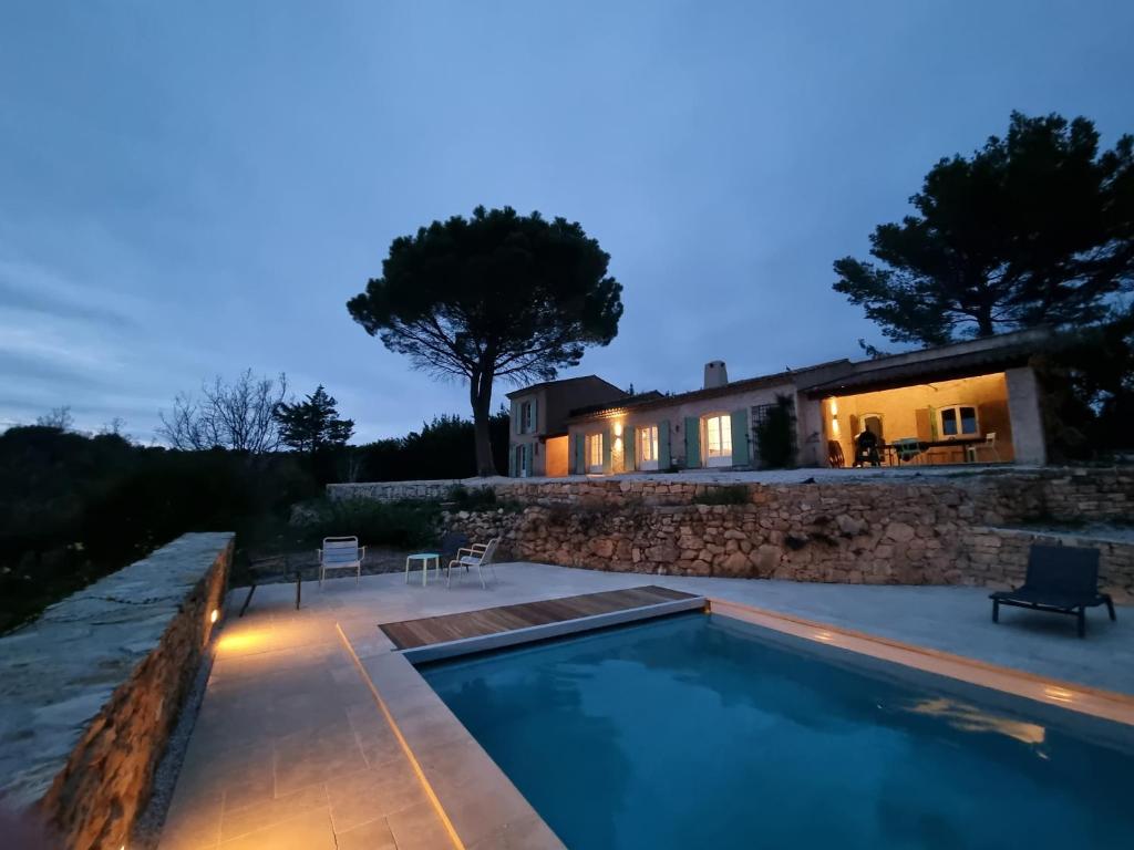 a swimming pool with a house in the background at Villa "L'élégante" avec vue imprenable in Tourtour
