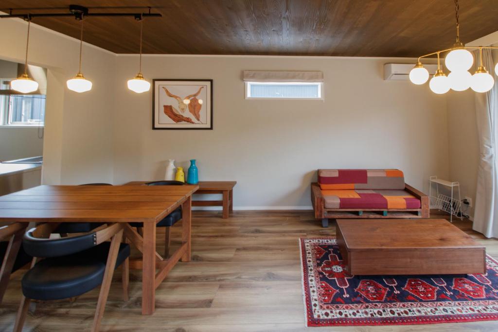 sala de estar con mesa y sofá en LOCALINO STAY AOSHIMA, en Miyazaki