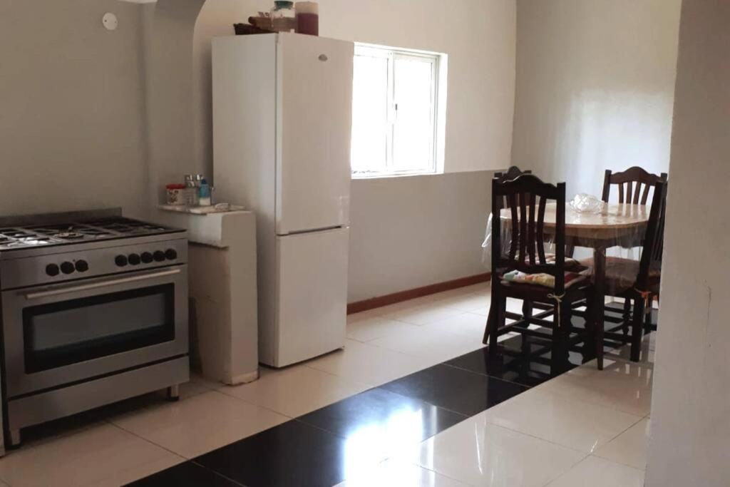 uma cozinha com um fogão, um frigorífico e uma mesa em Casa Tota em Assomada