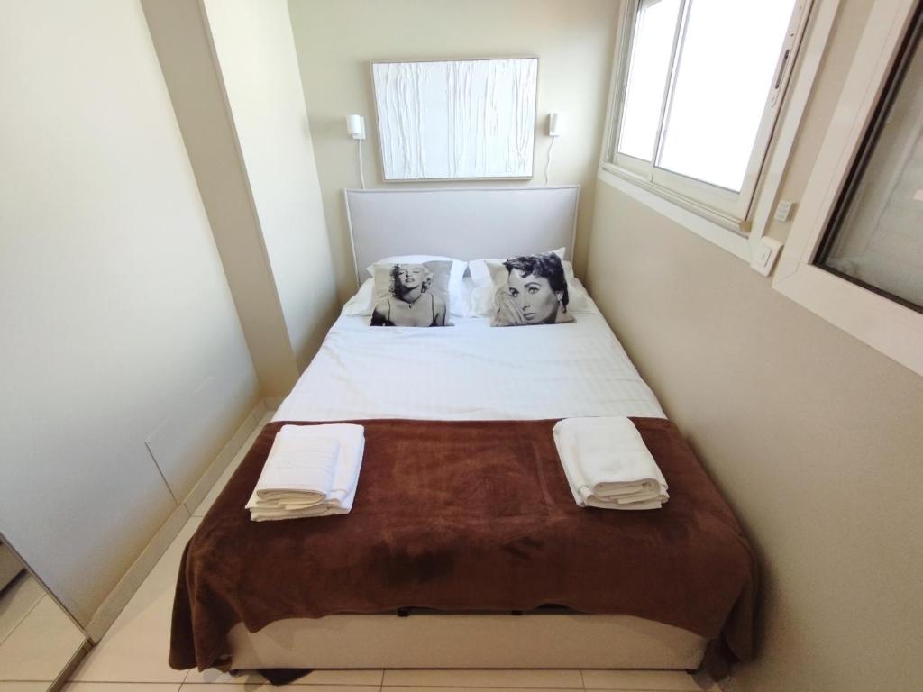 T2 Croisette & Palm Beach 2mi à pieds ! في كان: غرفة نوم صغيرة مع سرير مع اثنين من الكلاب على الوسائد