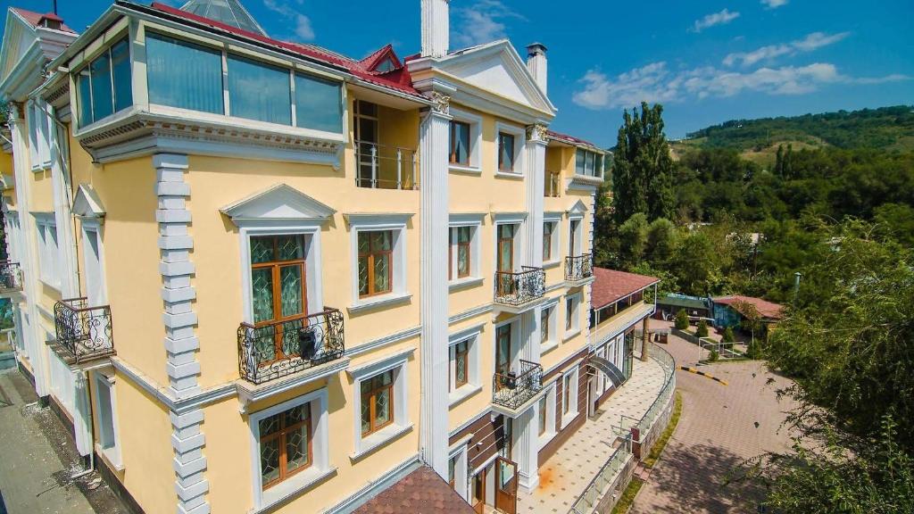 um grande edifício amarelo com janelas e varandas em AYKUN Hotel em Almaty