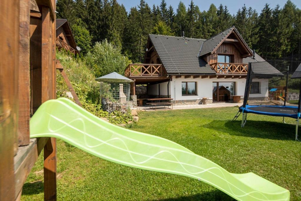 eine grüne Rutsche im Hof eines Hauses in der Unterkunft Apartmány Aram Kubínska hoľa in Dolný Kubín