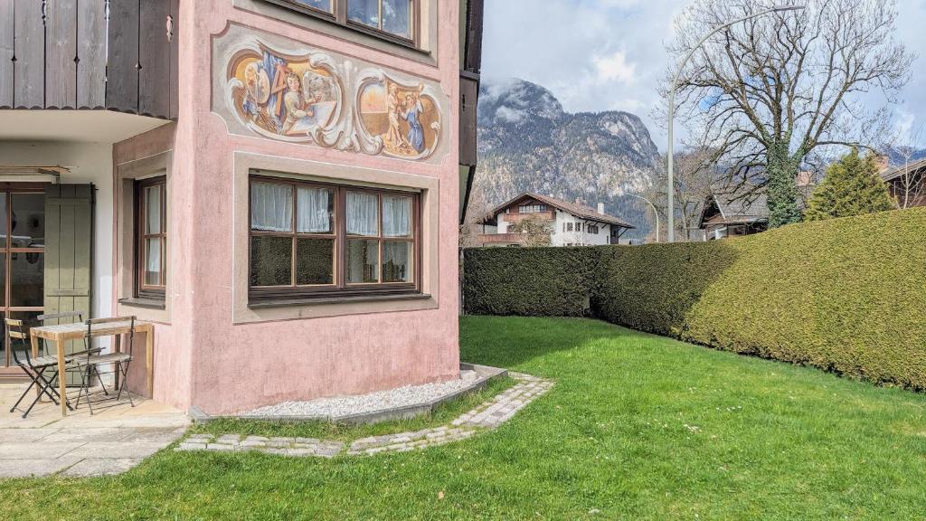 Uma casa cor-de-rosa com pinturas ao lado. em Calm GaP em Garmisch-Partenkirchen
