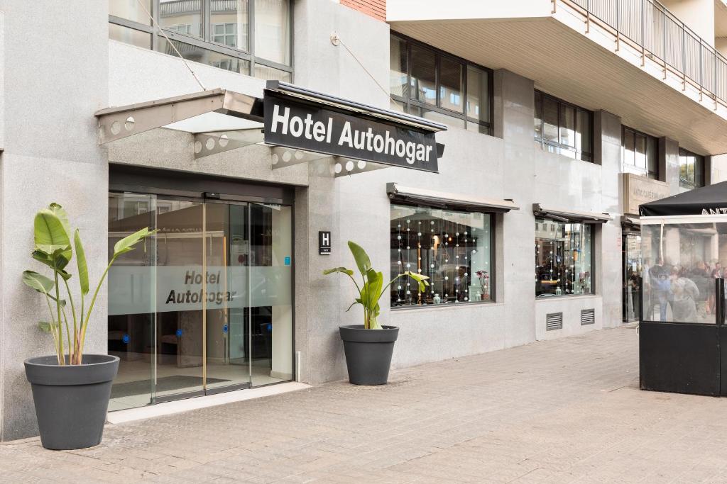 uma entrada do hotel com vasos de plantas em frente a um edifício em Hotel Best Auto Hogar em Barcelona