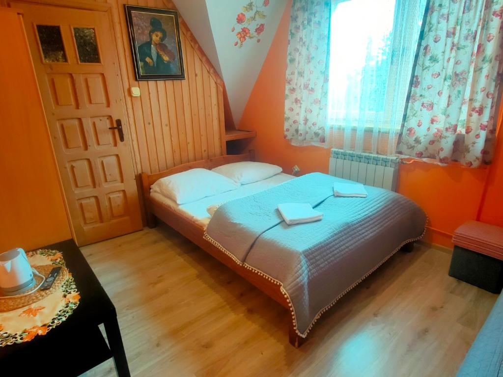 ein kleines Schlafzimmer mit einem Bett und einem Fenster in der Unterkunft Pokoje Gościnne Janina Bocheńczak in Gliczarów Górny