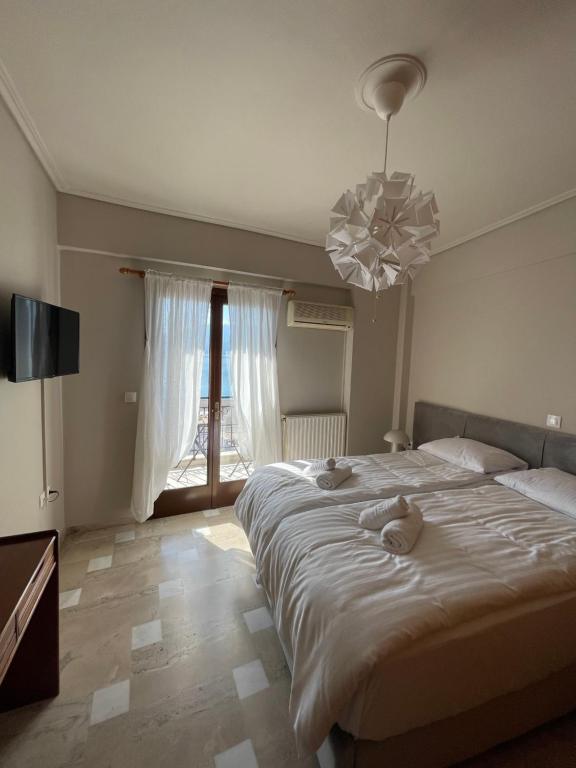 a bedroom with a large bed with two stuffed animals on it at Regina Hotel in Nafpaktos
