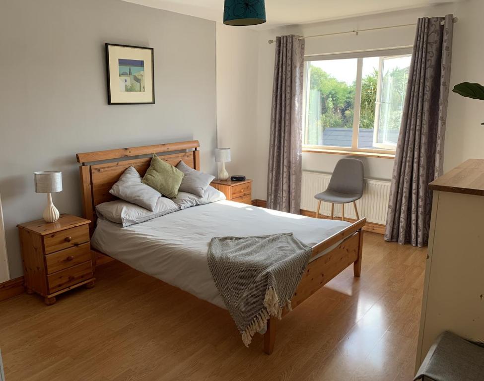 Un dormitorio con una cama grande y una ventana en Tramore Holidays, en Tramore