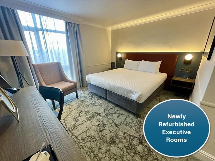 um quarto de hotel com uma cama e uma cadeira em London Croydon Aerodrome Hotel, BW Signature Collection em Croydon