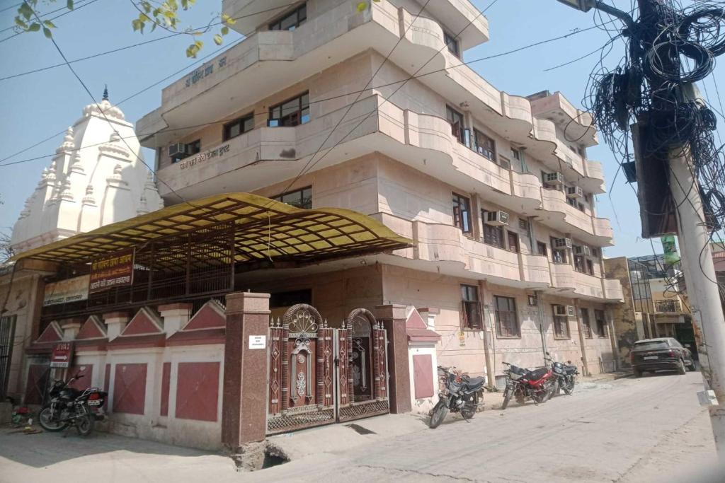 um edifício alto com motos estacionadas em frente em Govind Priya ashram em Vrindavan