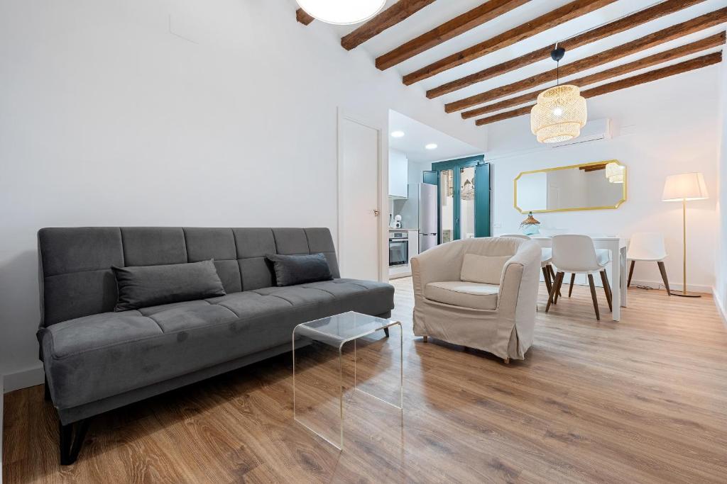 a living room with a couch and a chair and a table at Hauzify I Domus Merceria in Tarragona