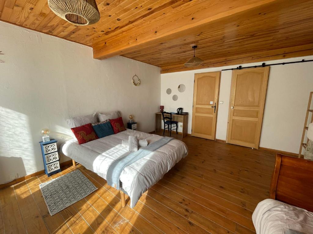 um quarto com uma cama e um tecto de madeira em L’Oiseau Doré em Bram
