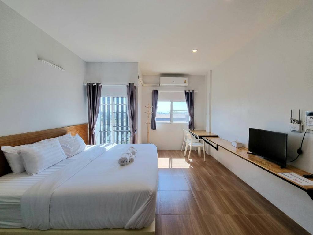 a hotel room with a bed and a television at Kandanai Place in Ban Du