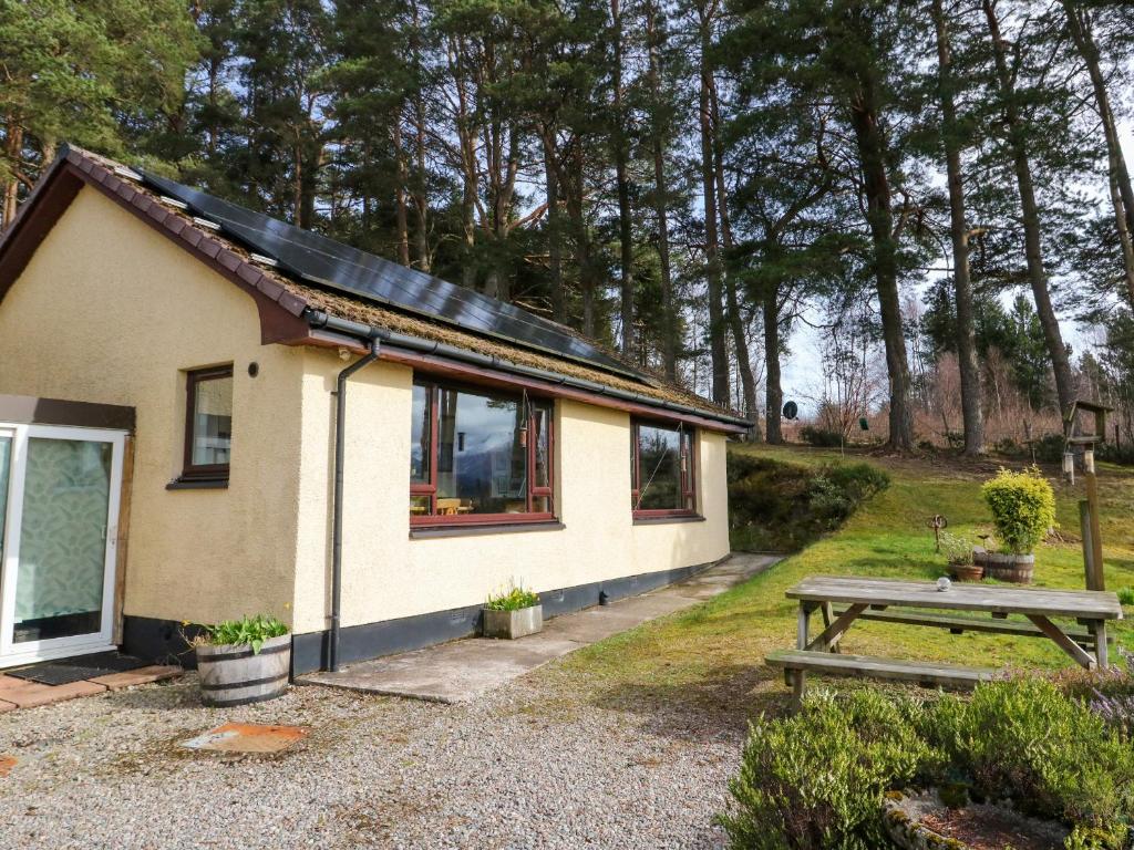 ein kleines Haus mit einem Picknicktisch davor in der Unterkunft Alba Ben View in Spean Bridge