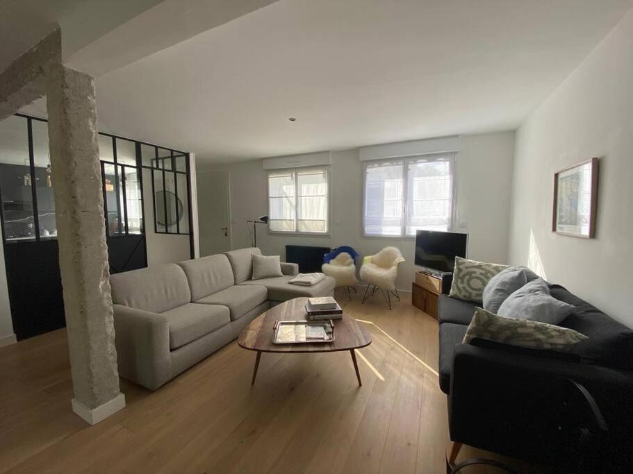 uma sala de estar com um sofá e uma mesa em Maison 3 chambres proche mer em Le Relecq-Kerhuon