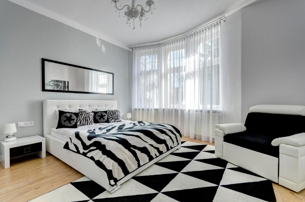 een slaapkamer met een bed met zebraprint en een stoel bij Platinum Residence - Chmielewskiego in Sopot