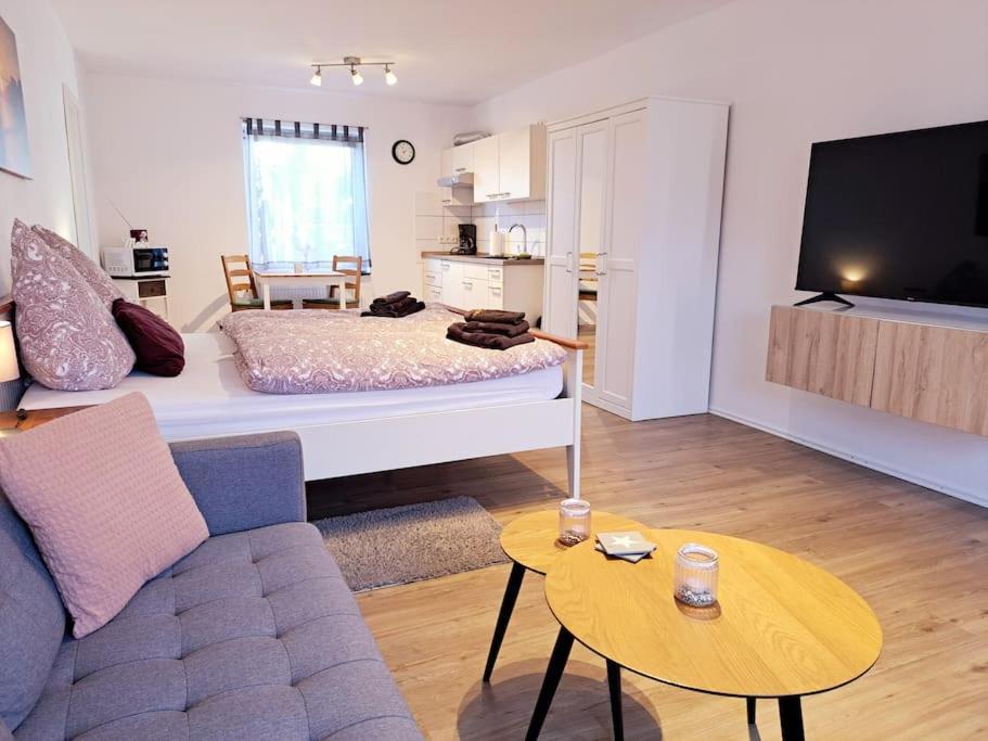 - un salon avec un lit et un canapé dans l'établissement Schönes 1-Zimmer-Appartement, Büsum (4km) Nordsee, à Oesterdeichstrich