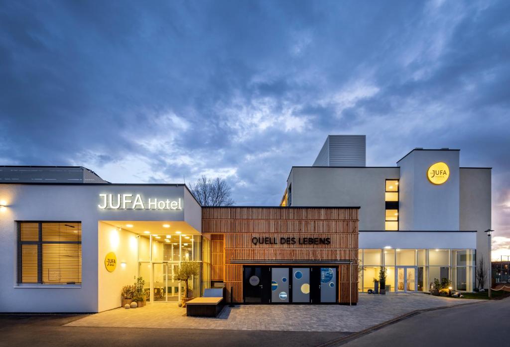 una tienda frente a un edificio con un banco delante en JUFA Hotel Bad Radkersburg - inkl 4h Thermeneintritt en Bad Radkersburg