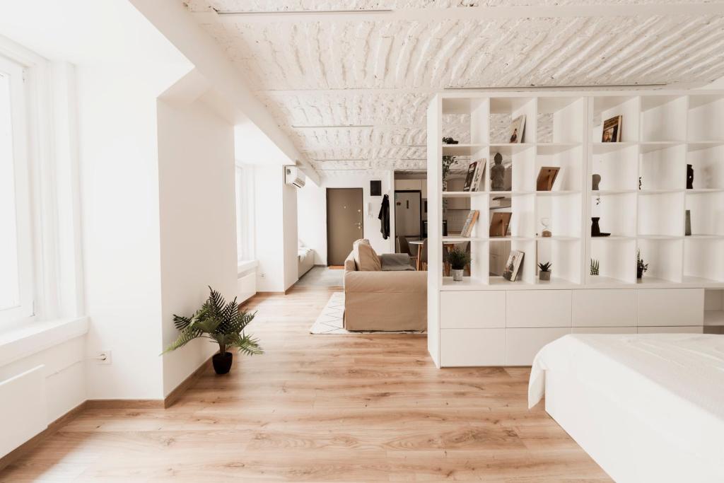 ブダペストにあるHeart of Budapest Apartmentの白いベッドルーム(ベッド1台、ソファ付)