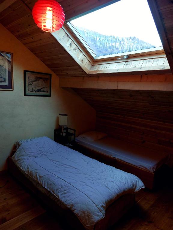 a bedroom with a bed and a large window at Les Airelles 33, Le coin, Molines en Queyras Classé 3 étoiles in Molines-en-Queyras