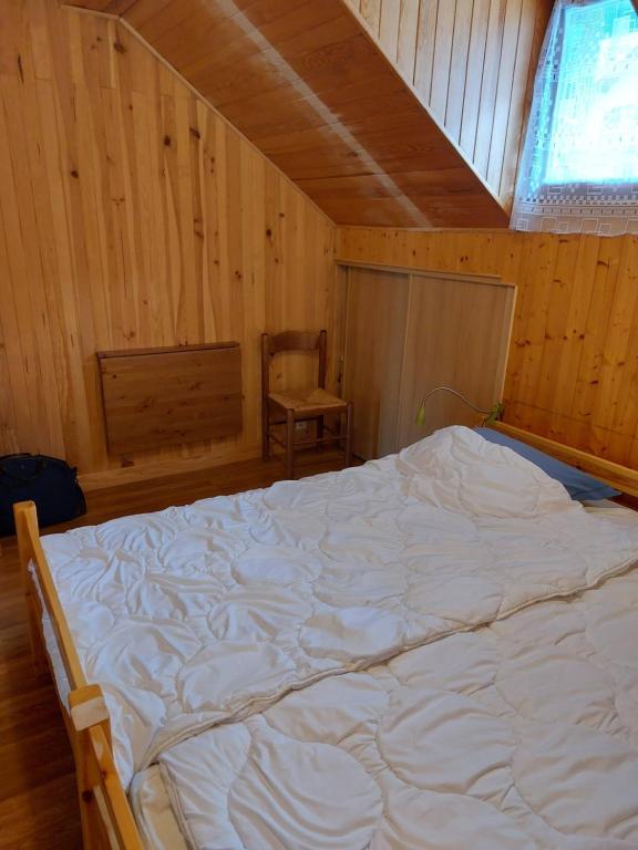 a bedroom with a large white bed in a cabin at Les Airelles 33, Le coin, Molines en Queyras Classé 3 étoiles in Molines-en-Queyras