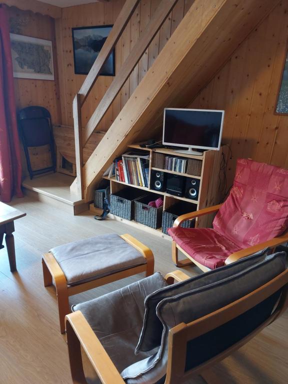 a living room with a couch and a tv at Les Airelles 33, Le coin, Molines en Queyras Classé 3 étoiles in Molines-en-Queyras