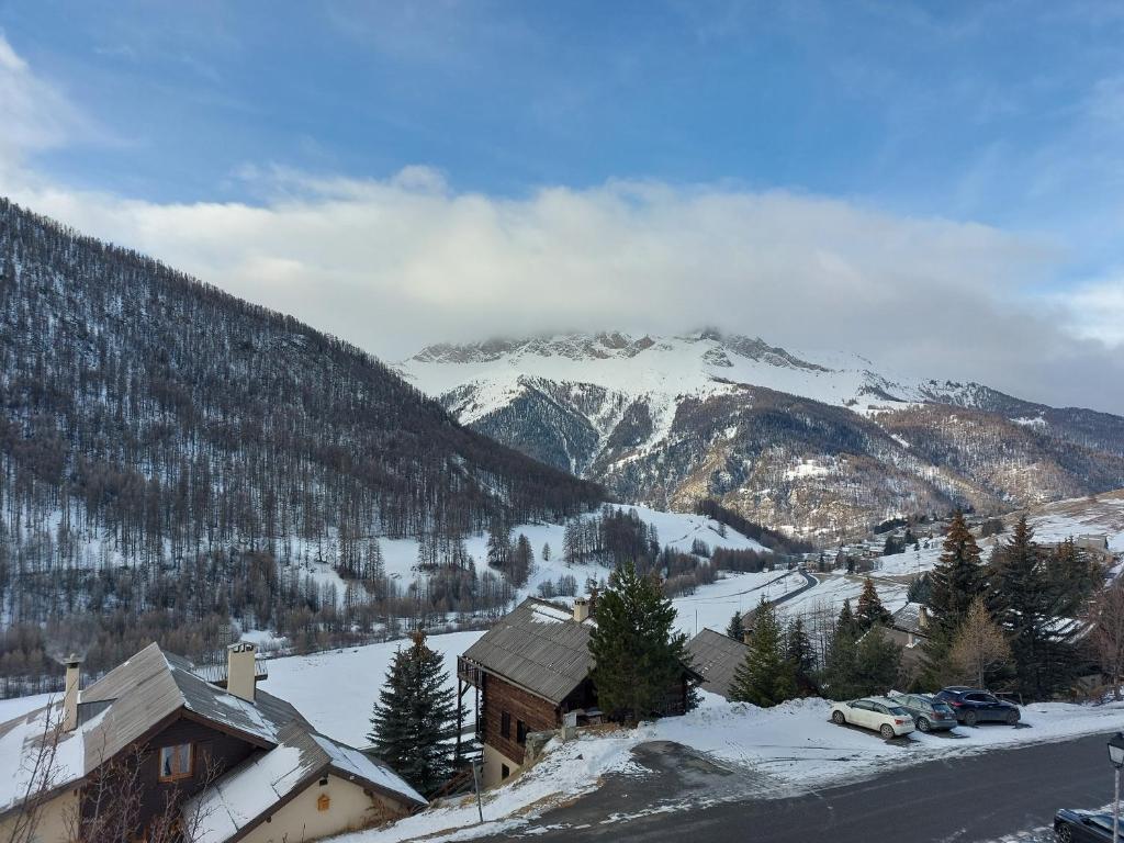 a snow covered mountain with a house and a road at Les Airelles 33, Le coin, Molines en Queyras Classé 3 étoiles in Molines-en-Queyras