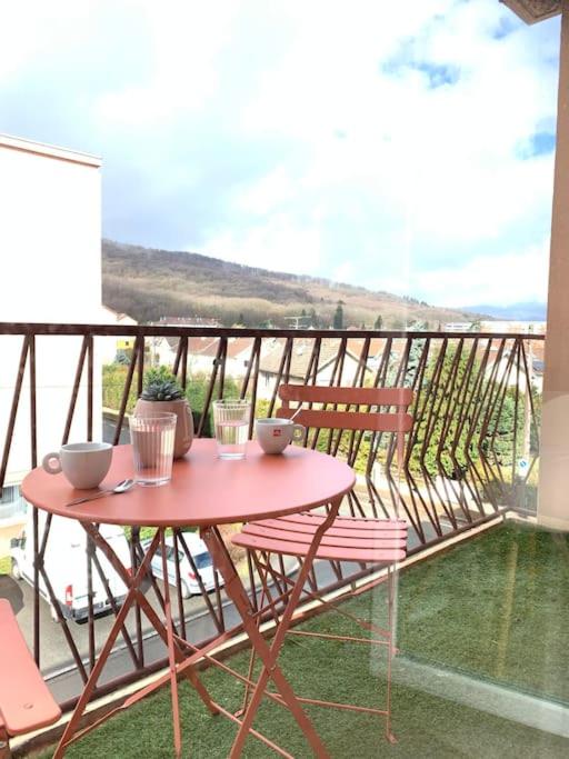 une table et des chaises sur un balcon avec vue dans l'établissement Appartement tout équipé proche General Electric, à Belfort