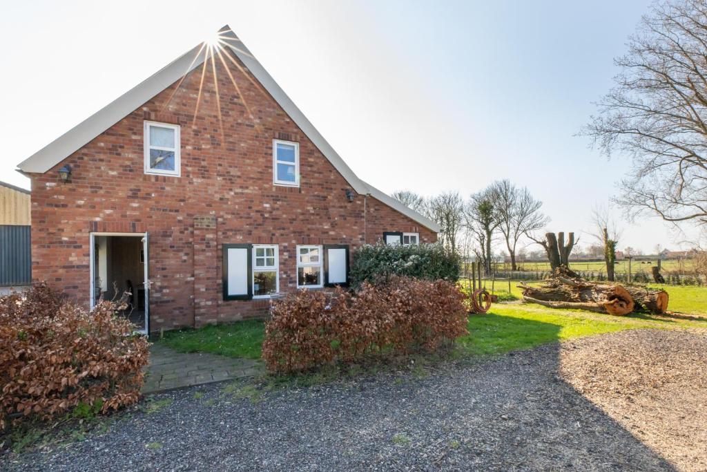 a brick house with a gambrel roof at Welcome in - Rustig gelegen gastenverblijf met eigen tuin, slaapkamer en badkamer in Koudekerke