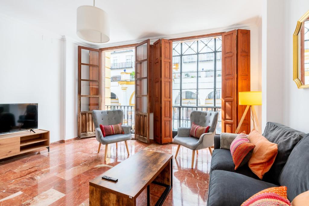 a living room with a couch and chairs and a tv at Veoapartment Pastor y Landero in Seville