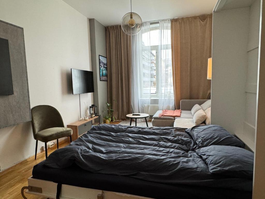 a bedroom with a bed and a living room at Studio apartment in Oslo