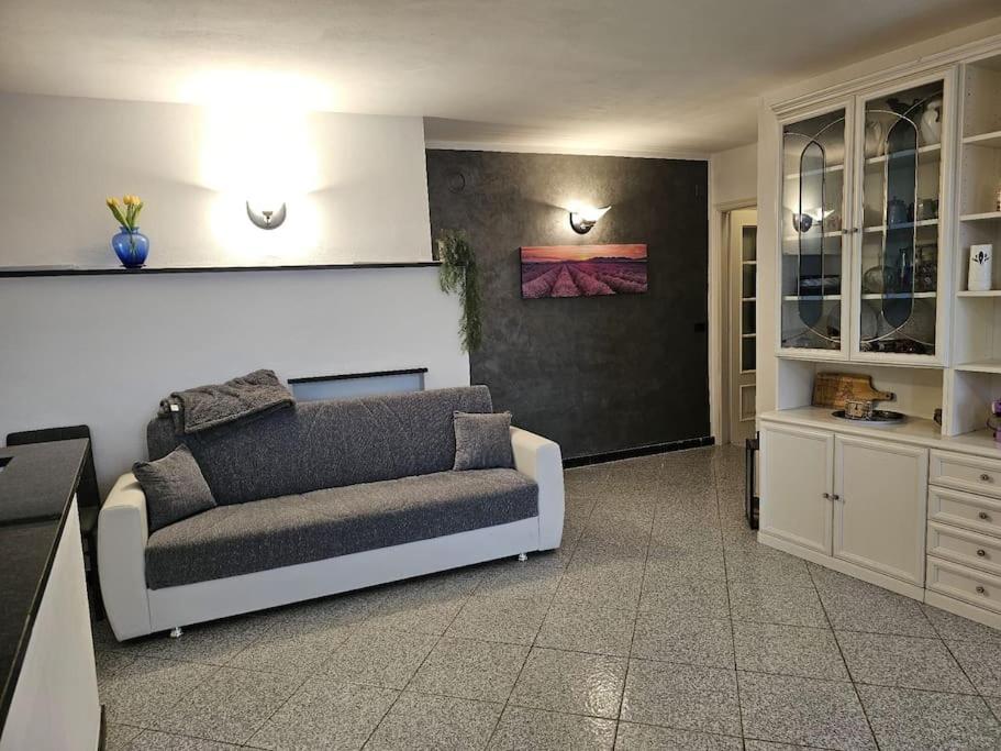 sala de estar con sofá y cocina en La Casa della Lavanda, en Borgo Adorno