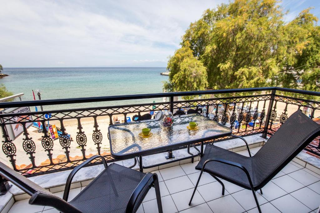 a balcony with a table and chairs and the ocean at Casa di Zou in Skala Marion