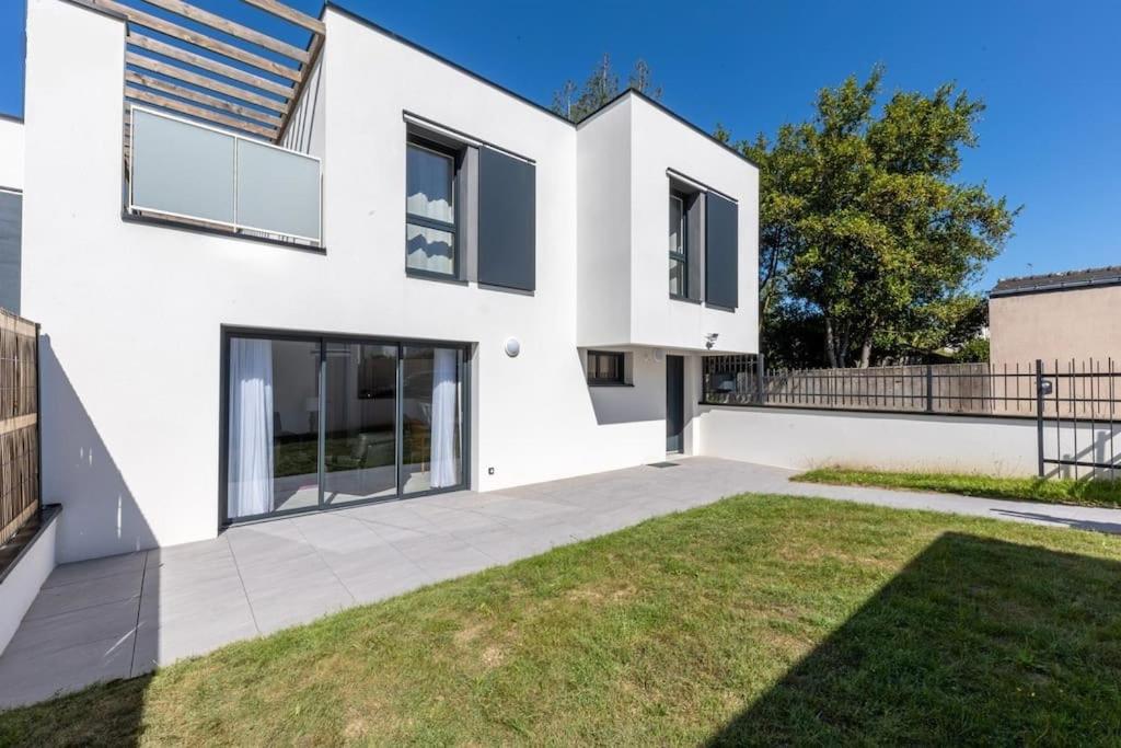 ein weißes Haus mit Rasen davor in der Unterkunft Villa 8 pers proche hypercentre parking gratuit in Vannes