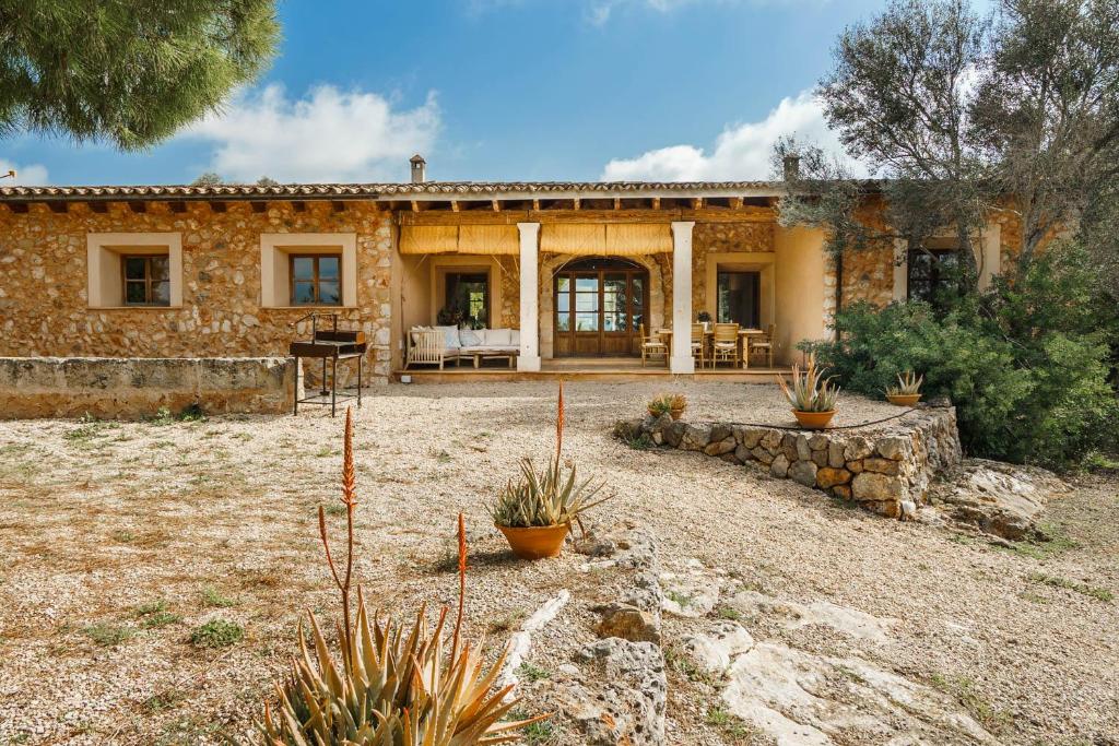 una gran casa de piedra con un patio con plantas en Es Pouet de Son Maiol, en Santa Maria del Camí