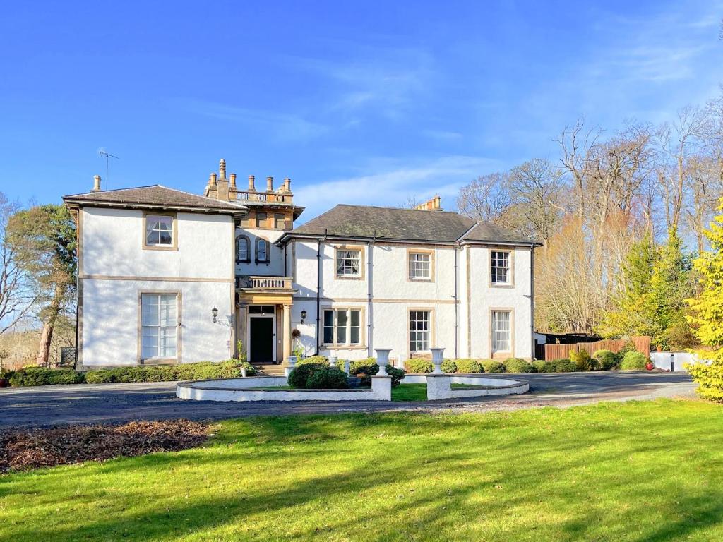 Arniston的住宿－The Mansion House At Kirkhill，一座带绿色草坪的大型白色房屋