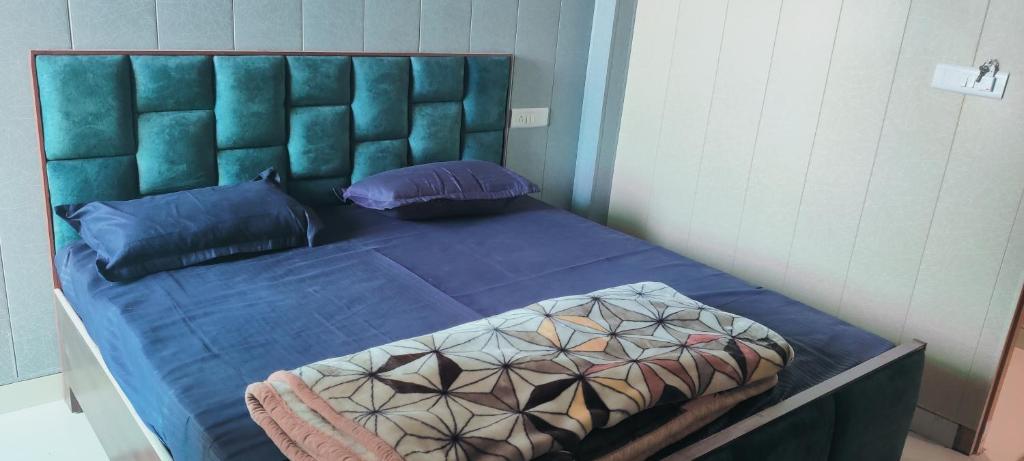 a bed with blue sheets and pillows in a room at Shri Ji Palace in Basāri