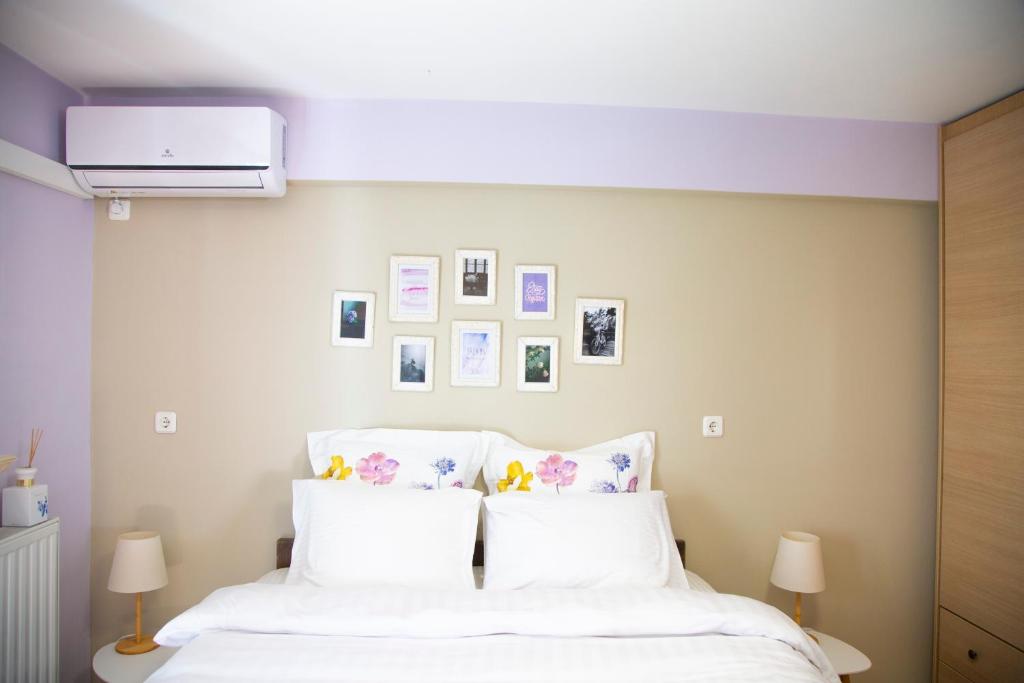 a bedroom with a bed with white sheets and pictures on the wall at Aesthetic Studio in Patra