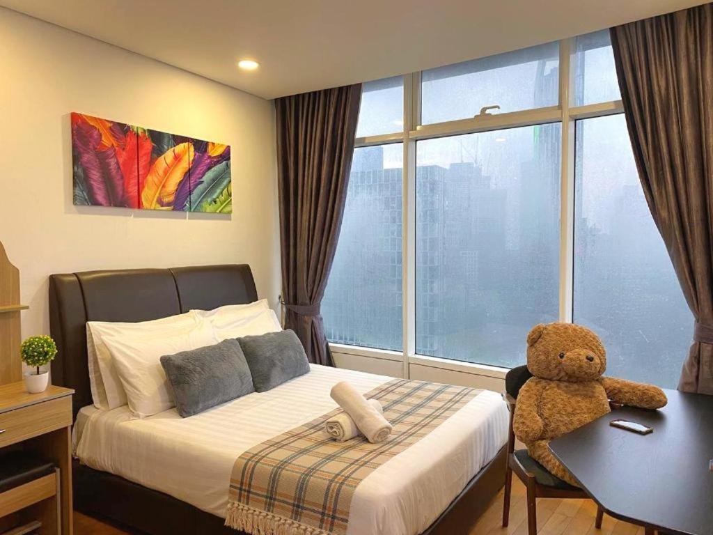 a bedroom with a bed with a teddy bear sitting on a desk at KL Cozy Apartment At Vortex KLCC in Kuala Lumpur