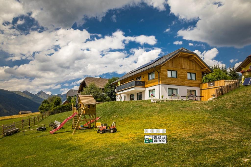 una casa en una colina con un tobogán y un parque infantil en Praschhof en Mariapfarr