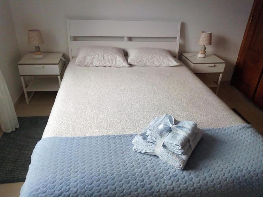 a bedroom with a large bed with towels on it at Azure Guest House in Silveira