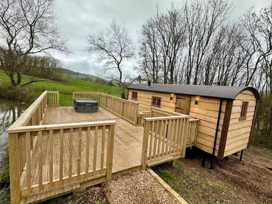 a large wooden deck with a grill on it at Shepherds Hut/Hot Tub Private Lake Jurassic Coast in Bridport