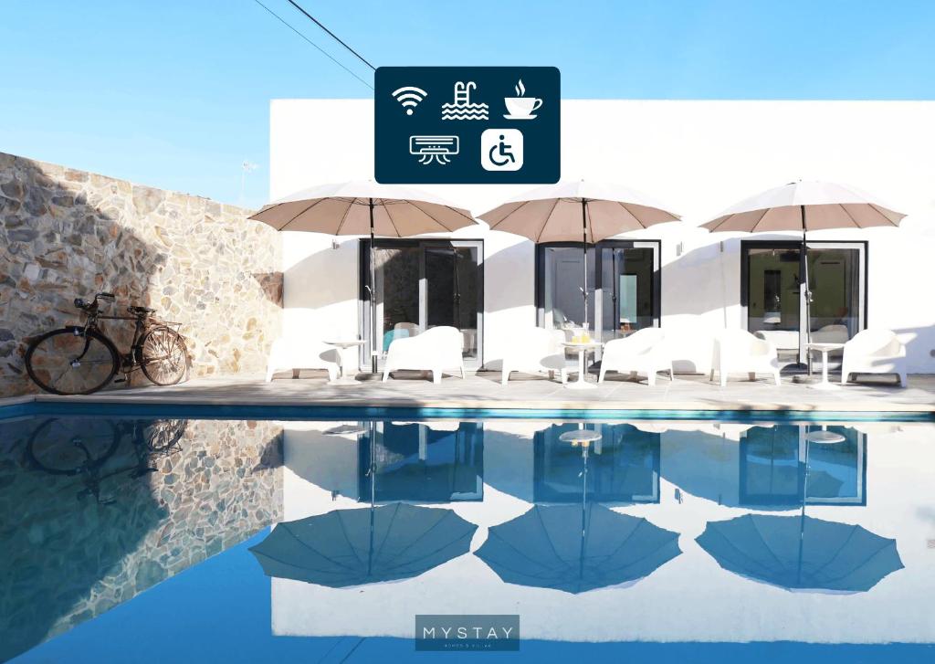 Igrejinha的住宿－MyStay - Casa de Baco，游泳池旁的标志,上面有椅子和遮阳伞